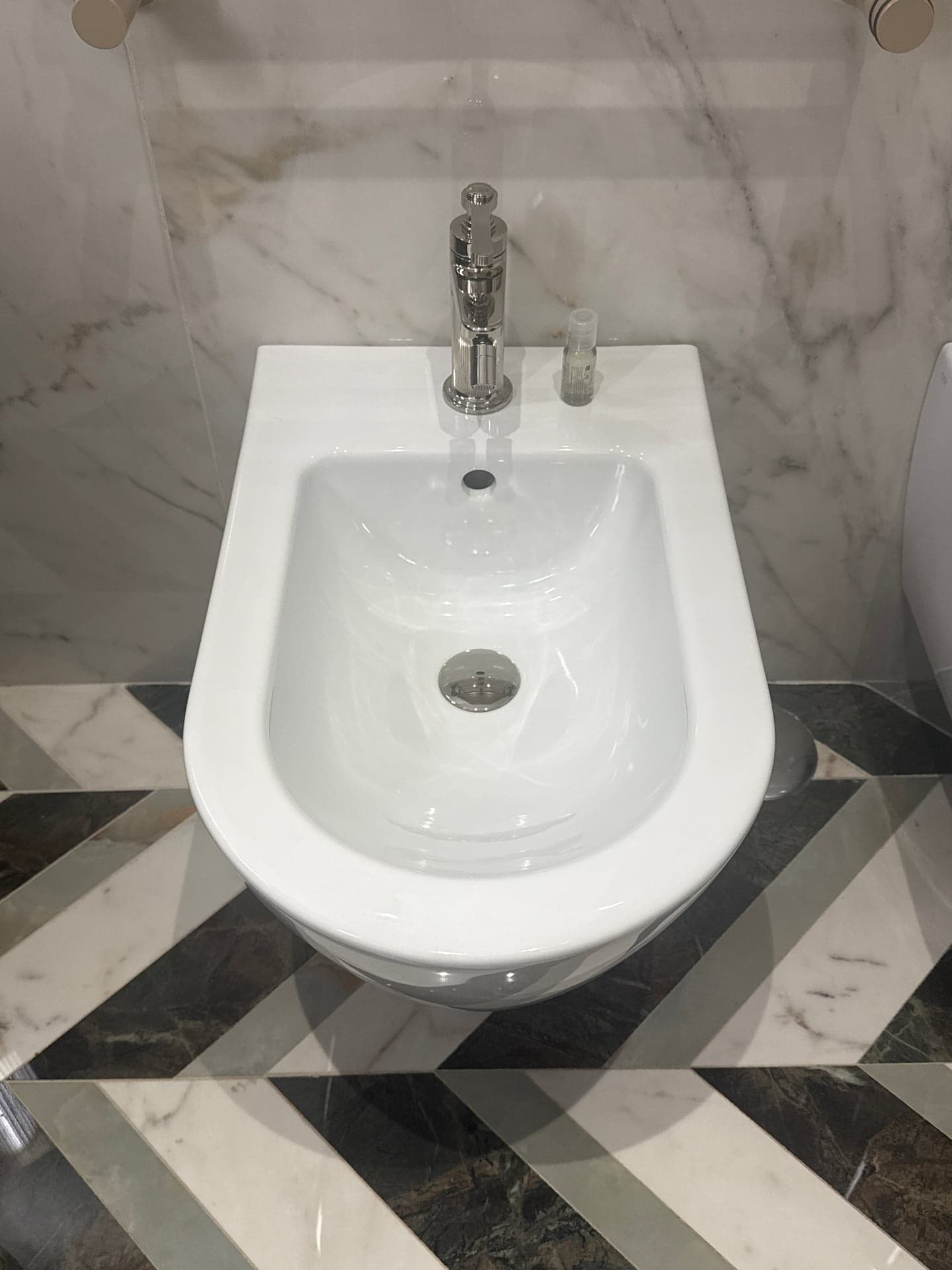 Wall-Hung White Ceramic Bidet with Chrome Faucet and In-Wall Carrier